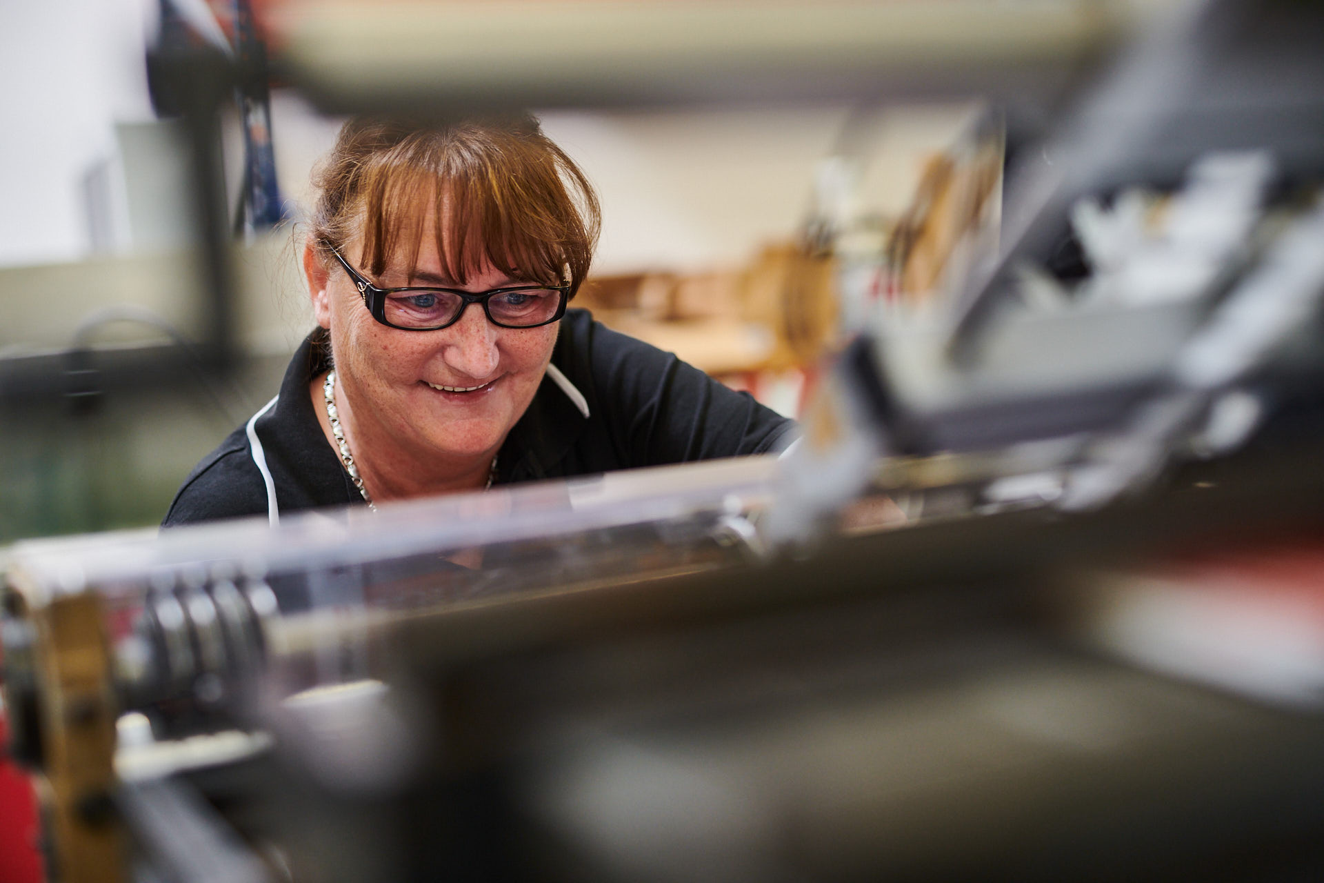 Foto einer Mitarbeiterin an einer Druckmaschine.